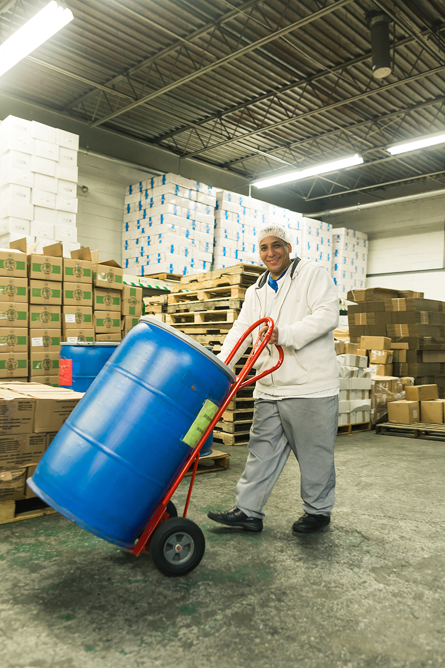 Warehouse worker pushing a barrel.